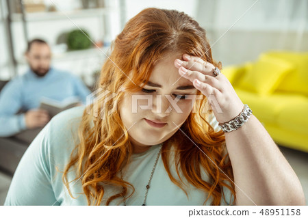 Worried red-haired woman standing on the foreground Worried red-haired woman standing on the foreground 48951158