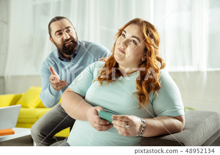 Dreamy curly-haired female listening to her interlocutor 48952134