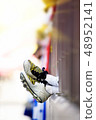A boy watching footsteps in a playground or stadium, a boy wearing a soccer shoes 48952141