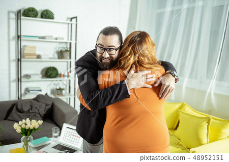 Positive delighted bearded male person embracing his partner Positive delighted bearded male person embracing his partner 48952151