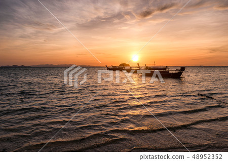 Wooden long-tail boats on tropical sea at sunrise 48952352