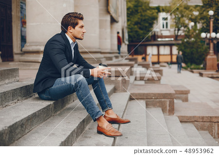 Handsome businesman in a summer city Handsome businesman in a summer city 48953962