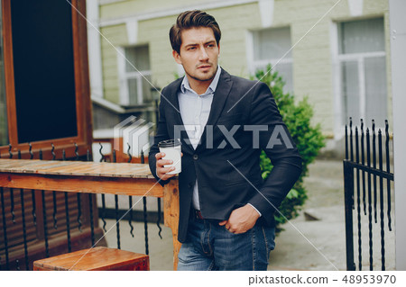 Handsome businesman in a summer city Handsome businesman in a summer city 48953970