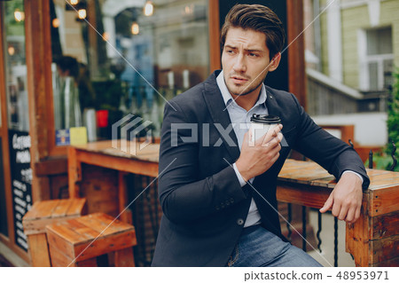 Handsome businesman in a summer city Handsome businesman in a summer city 48953971