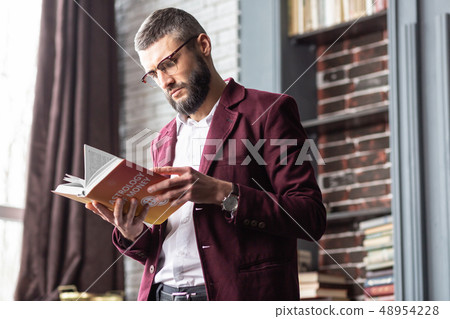Businessman feeling interested reading book about astrology and money Businessman feeling interested reading book about astrology and money 48954228