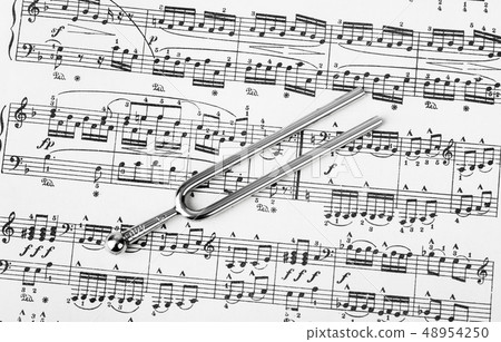 Pitchfork on sheet music - art background Pitchfork on sheet music - art background 48954250