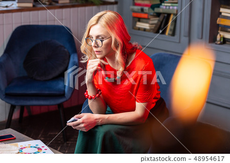 Blonde-haired wisewoman feeling inspired while reading oracle cards 48954617