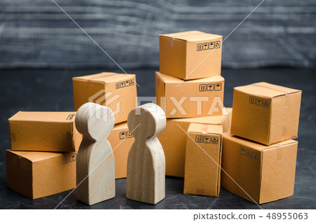 Two people discuss a business deal in a warehouse. 48955063