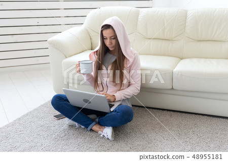 People, freelance and technologies concept - young woman drinking tea on the floor. Laptop and People, freelance and technologies concept - young woman drinking tea on the floor. Laptop and 48955181