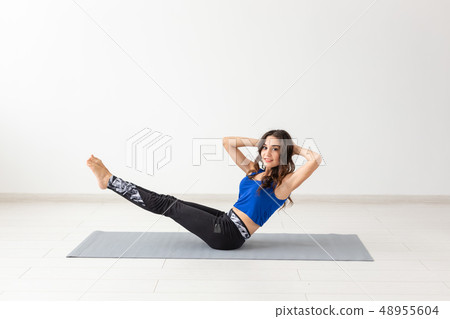 Sport, people concept - young woman swinging press by statics exercises Sport, people concept - young woman swinging press by statics exercises 48955604