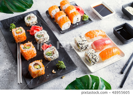 Various Fresh and delicious sushi set on black and white slate with metal and slate sticks, sauce Various Fresh and delicious sushi set on black and white slate with metal and slate sticks, sauce 48955605