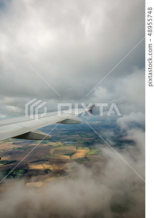 Airplane flying above the english countryside 48955748