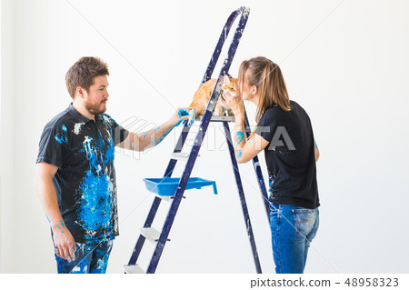 Renovation, repair and family concept - a young couple with cat doing renovation in new home 48958323