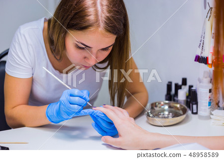 Manicurist master makes manicure Manicurist master makes manicure 48958589