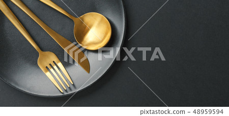 Gold cutlery set on black background Gold cutlery set on black background 48959594