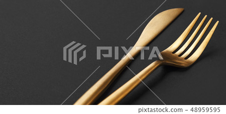 Gold cutlery set on black background Gold cutlery set on black background 48959595