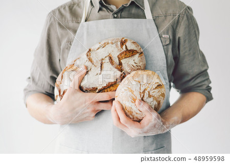 Baker or chef holding fresh made bread Baker or chef holding fresh made bread 48959598