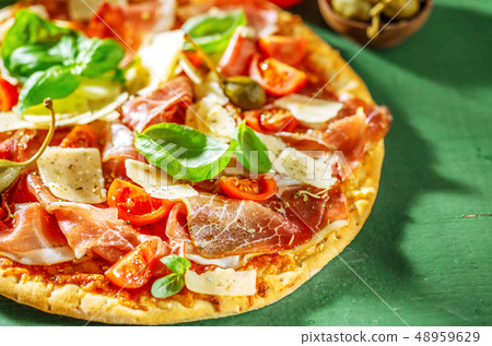 Appetizing italian pizza with prosciutto Appetizing italian pizza with prosciutto 48959629
