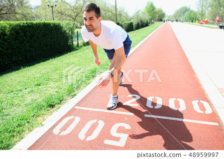 Athletic man on track starting to run Athletic man on track starting to run 48959997