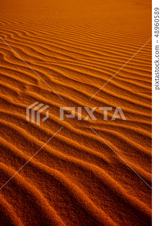 orange toned sand background with a wavy pattern. orange toned sand background with a wavy pattern. 48960589