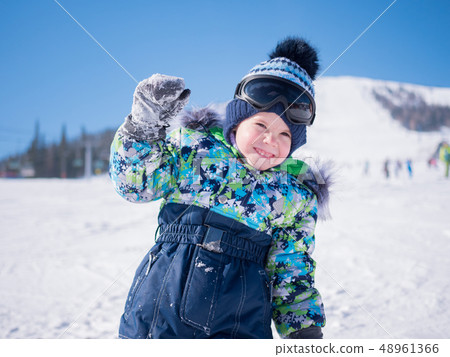 A small child walks in the winter Park. Playing and smiling baby on white fluffy snow. Active rest A small child walks in the winter Park. Playing and smiling baby on white fluffy snow. Active rest 48961366