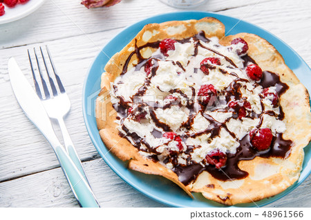Homemade pancakes or Russian pancakes with chocolate sauce, whipped cream and raspberries 48961566