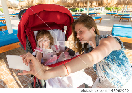 Mother taking selfie with baby on resort 48962020