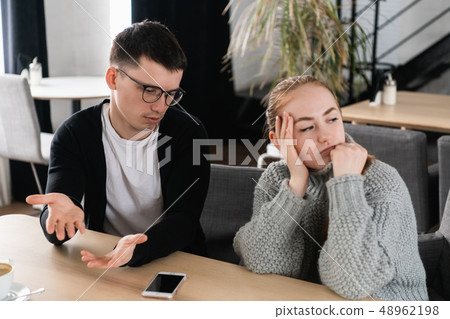 Annoyed man trying to explain something to his wife 48962198