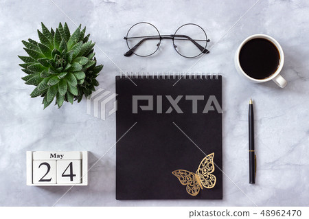 Office or home table desk. Wooden cubes calendar May 24. Black notepad, cup of coffee, succulent 48962470