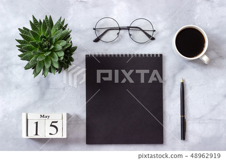 Office or home table desk. Wooden cubes calendar May 15. Black notepad, cup of coffee, succulent Office or home table desk. Wooden cubes calendar May 15. Black notepad, cup of coffee, succulent 48962919