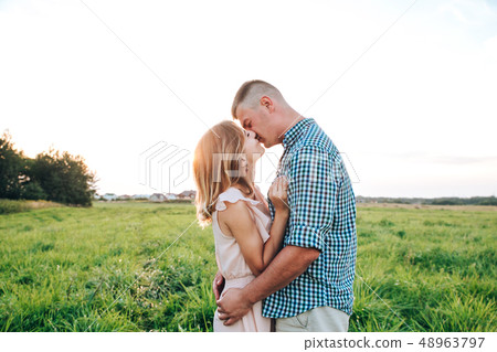 Young attractive couple in love kissing in summer in field. Young attractive couple in love kissing in summer in field. 48963797