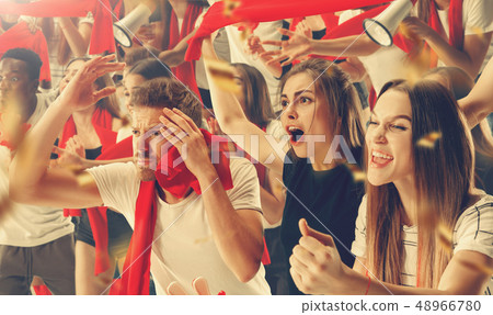 Group of happy fans are cheering for their team victory. 48966780