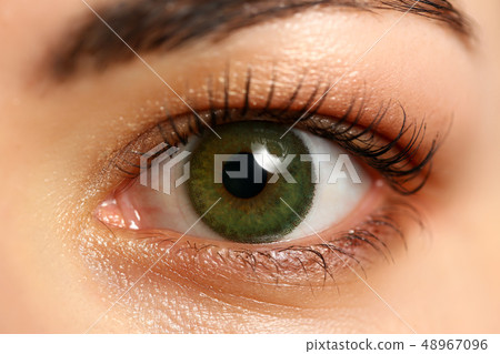 Female left emerald green coloured eye extreme closeup 48967096