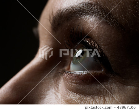 Female left green coloured eye extreme closeup 48967106