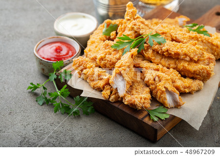 Breaded chicken strips with two kinds of sauces. Breaded chicken strips with two kinds of sauces. 48967209