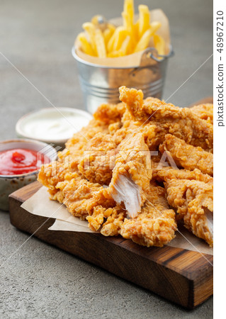 Breaded chicken strips with two kinds of sauces. Breaded chicken strips with two kinds of sauces. 48967210