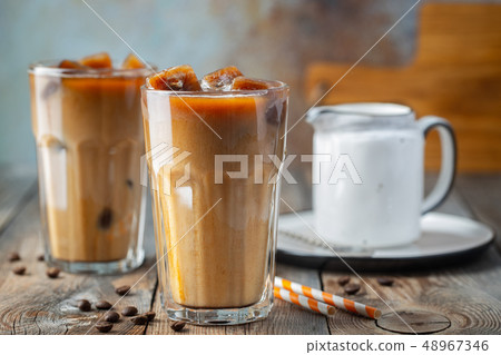Ice coffee in a tall glass with cream. Ice coffee in a tall glass with cream. 48967346