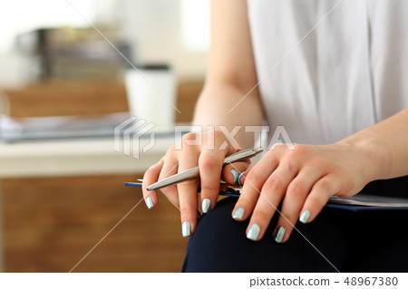 Female arm in suit hold silver pen 48967380