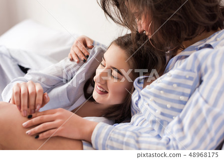 Close-up of woman huging another in bed. Close-up of woman huging another in bed. 48968175