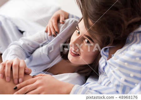 Close-up of woman huging another in bed. Close-up of woman huging another in bed. 48968176