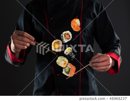 Master chef holding chopsticks with flying sushi 48968237