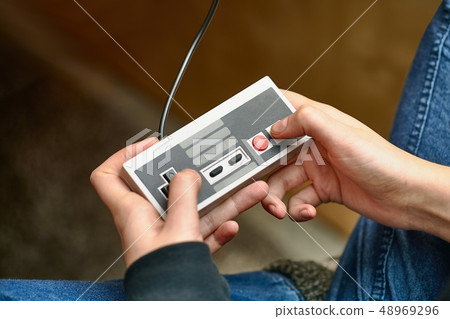 Playing an old gaming console Playing an old gaming console 48969296