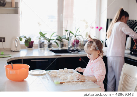 Little lovely kid helping parent with dough at Little lovely kid helping parent with dough at 48969348