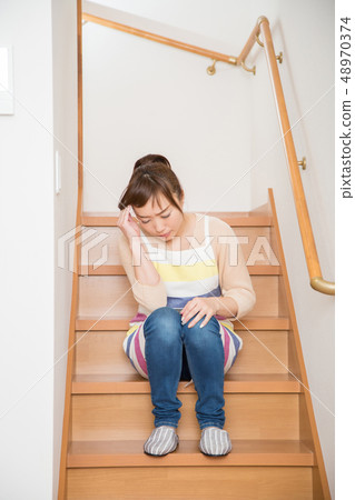 A woman thinking something on the stairs A woman thinking something on the stairs 48970374