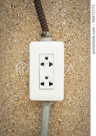 Dangerous electricity plug socket on wall  48972772