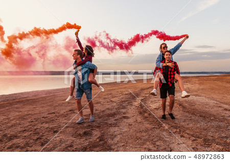 young friends running with hand flare or fusee young friends running with hand flare or fusee 48972863