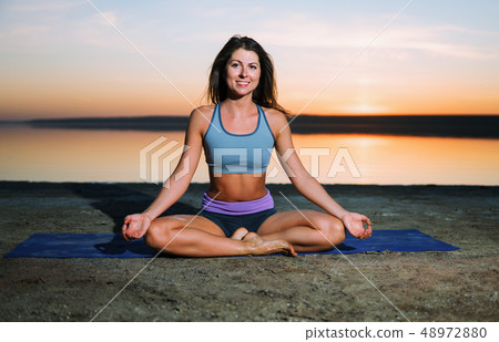yoga woman on the beach at sunset. yoga woman on the beach at sunset. 48972880