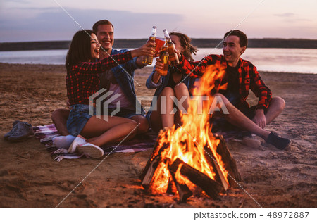 young friends have picnic with bonfire on the beach young friends have picnic with bonfire on the beach 48972887