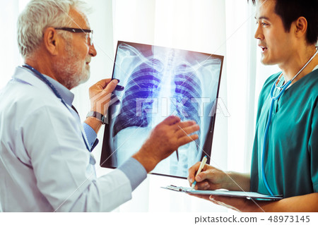 Doctors working with x ray film of patient chest. Doctors working with x ray film of patient chest. 48973145