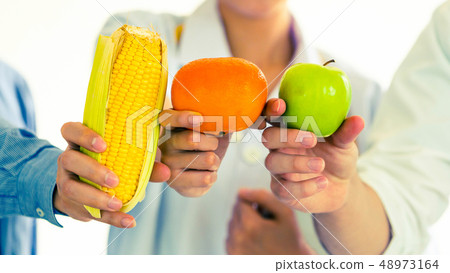 Group of nutritionist presenting healthy diet food Group of nutritionist presenting healthy diet food 48973164